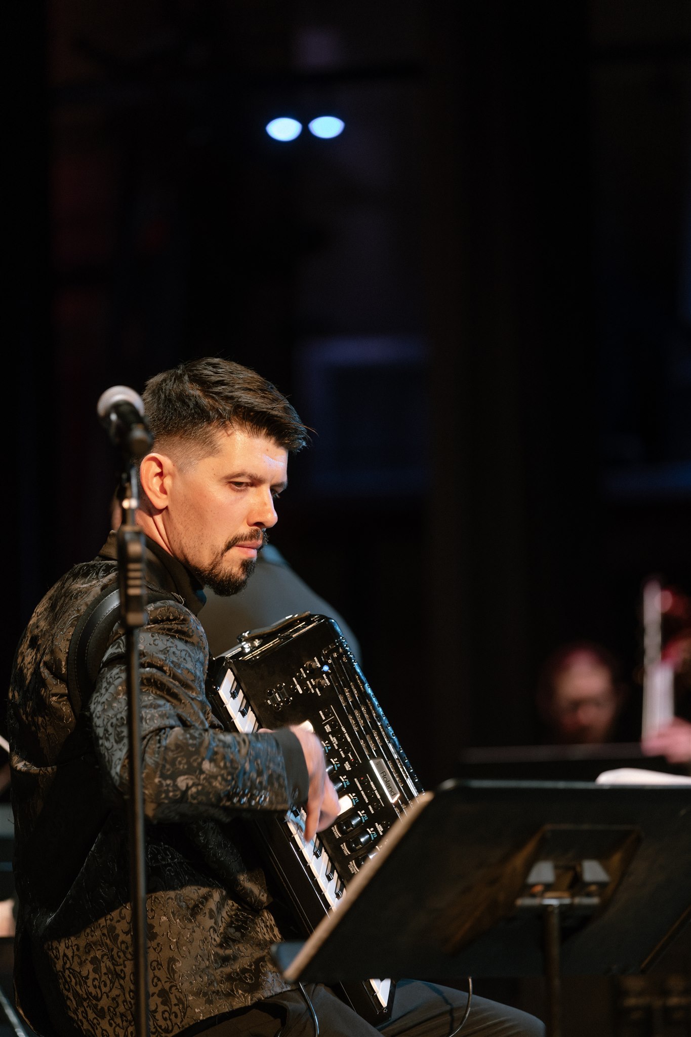 Aleksei Chebeliuk performing with accordion on stage